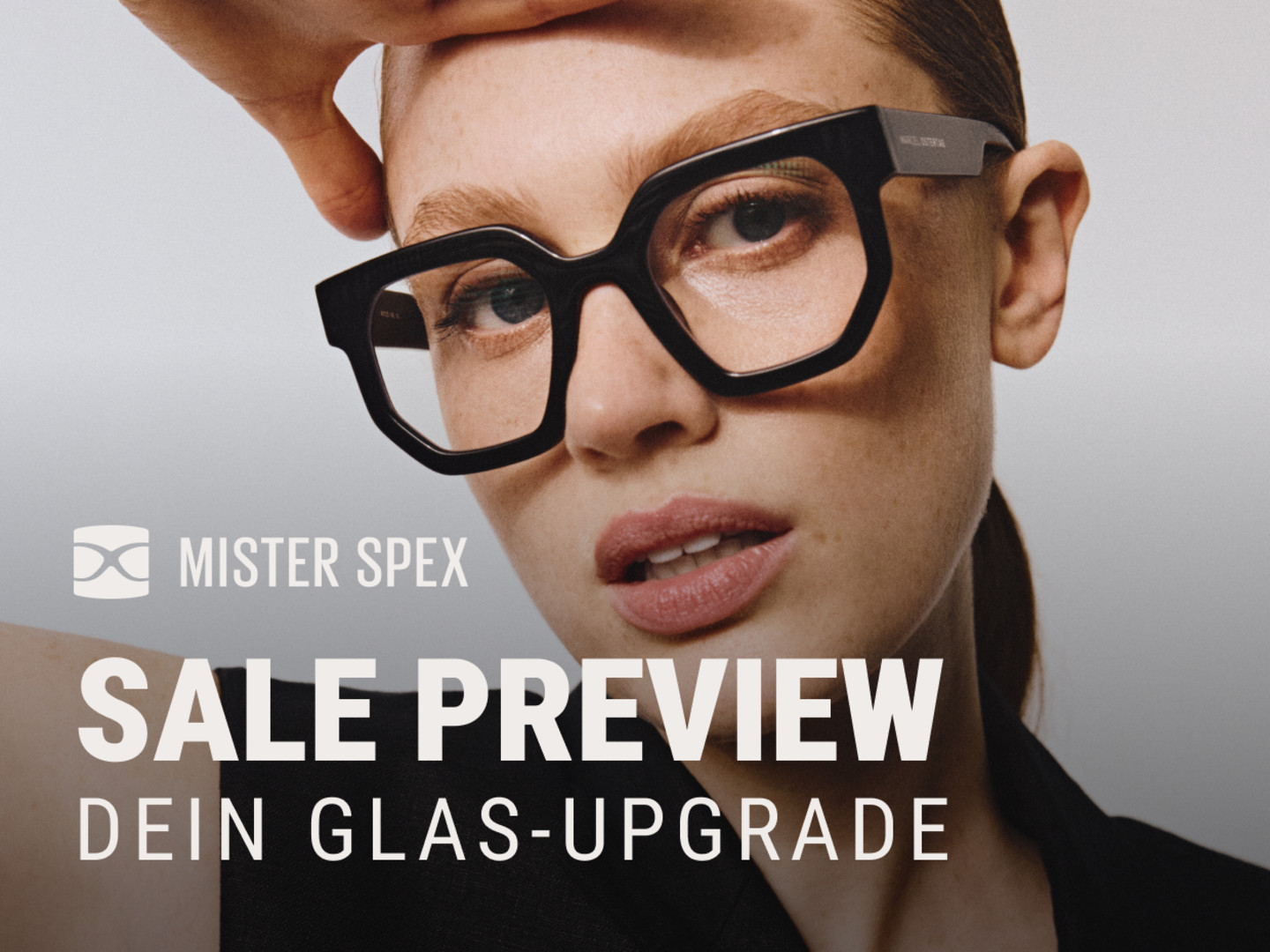 Weibliches Model trägt eine Brille mit auffälligem schwarzem Kunststoffrahmen. Am unteren Rand steht "Mister Spex; Sale Preview - Dein Glas-Upgrade"